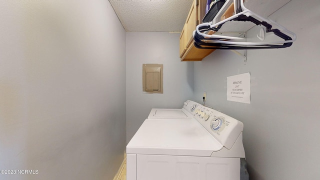 clothes washing area with cabinets, independent washer and dryer, and a textured ceiling