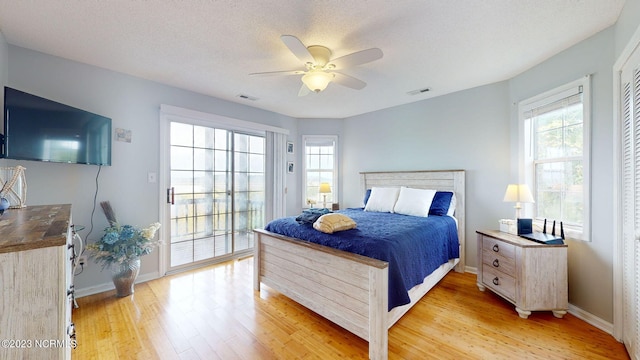 bedroom featuring ceiling fan, a textured ceiling, and light wood-type flooring