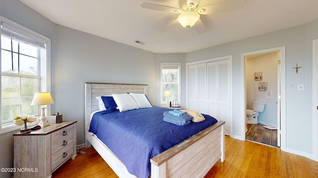 bedroom with multiple windows, hardwood / wood-style floors, and a closet