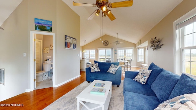 living room featuring ceiling fan, high vaulted ceiling, and light hardwood / wood-style floors