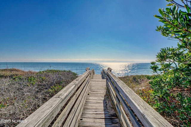 surrounding community featuring a water view and a beach view