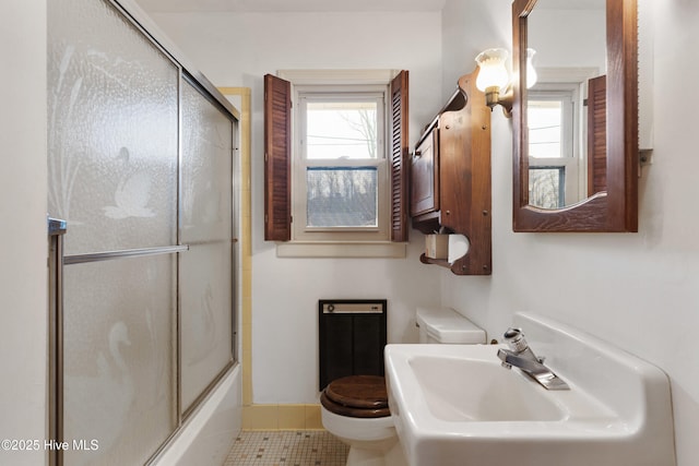 full bathroom with bath / shower combo with glass door, plenty of natural light, sink, and toilet