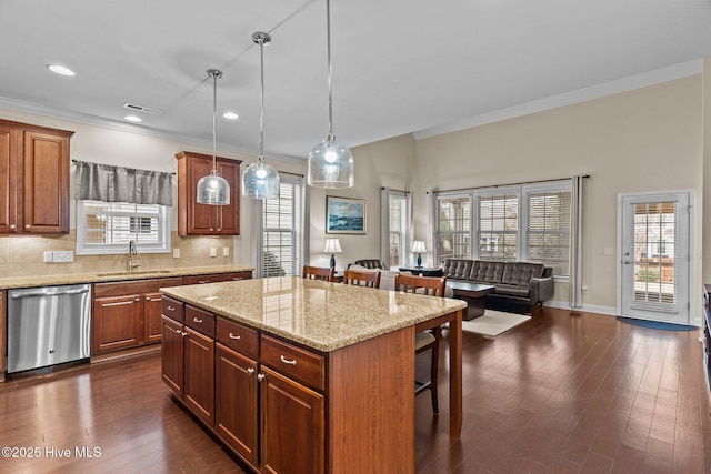 kitchen with a kitchen island, decorative light fixtures, sink, a kitchen breakfast bar, and stainless steel dishwasher