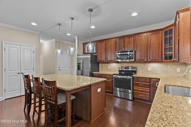 kitchen featuring sink, hanging light fixtures, stainless steel appliances, light stone counters, and decorative backsplash