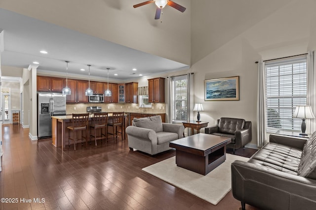 living room featuring sink, crown molding, dark wood-type flooring, and ceiling fan