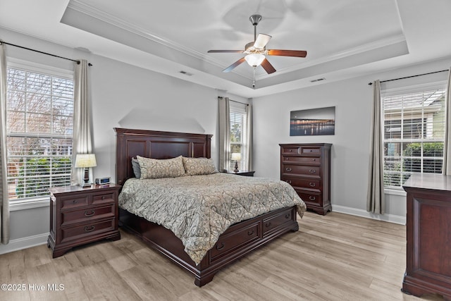 bedroom with crown molding, ceiling fan, a raised ceiling, and light wood-type flooring