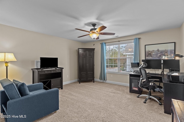 carpeted home office featuring ceiling fan