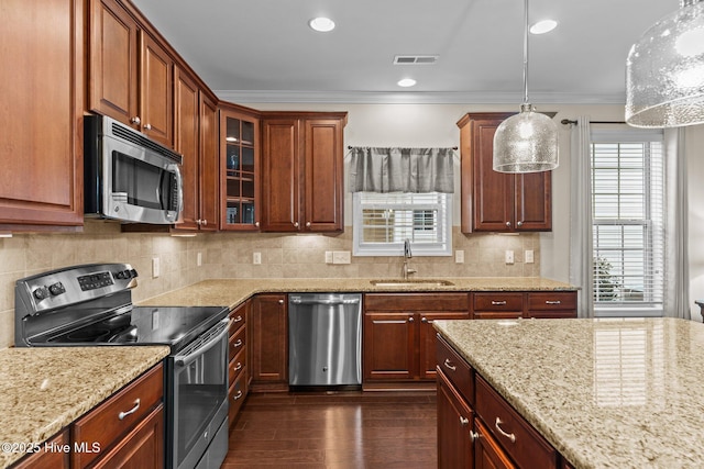 kitchen featuring hanging light fixtures, crown molding, appliances with stainless steel finishes, and sink