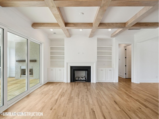 unfurnished living room with coffered ceiling, light wood-style flooring, built in shelves, a fireplace, and beam ceiling