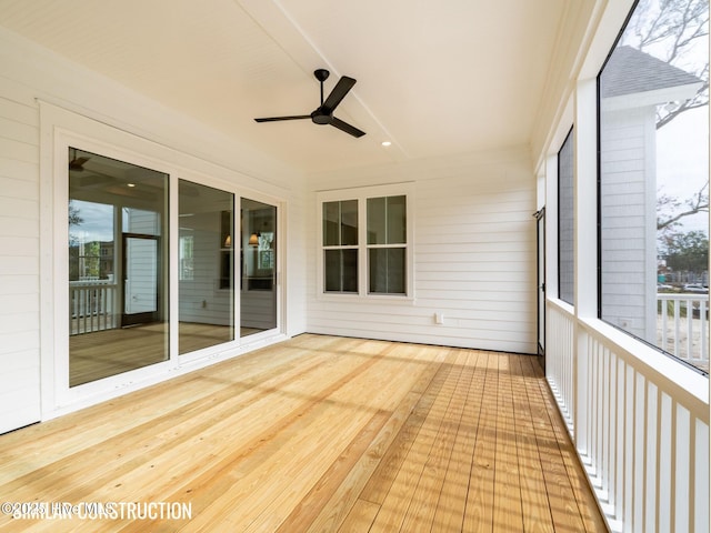 unfurnished sunroom featuring ceiling fan