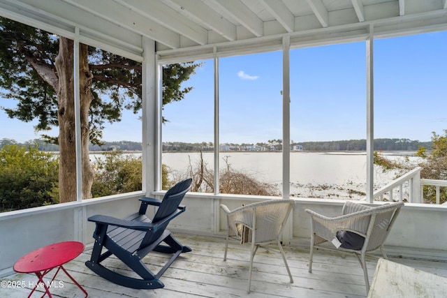 sunroom / solarium featuring plenty of natural light and a water view