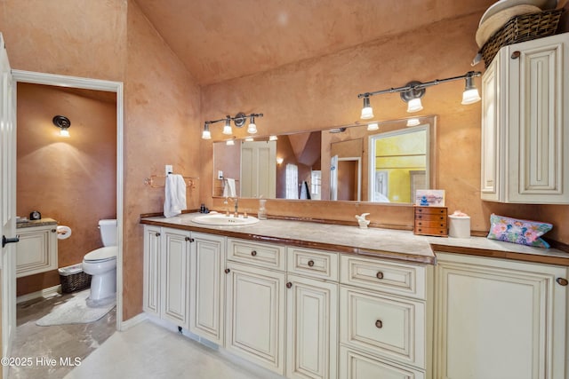 bathroom with vanity, vaulted ceiling, and toilet