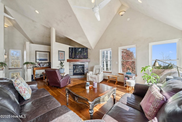 living room with wood-type flooring, high vaulted ceiling, ceiling fan, and a fireplace