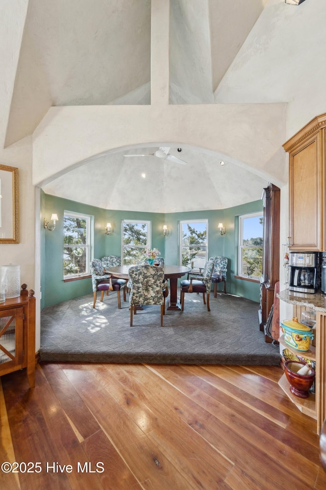 dining space featuring dark hardwood / wood-style floors, a wealth of natural light, and high vaulted ceiling