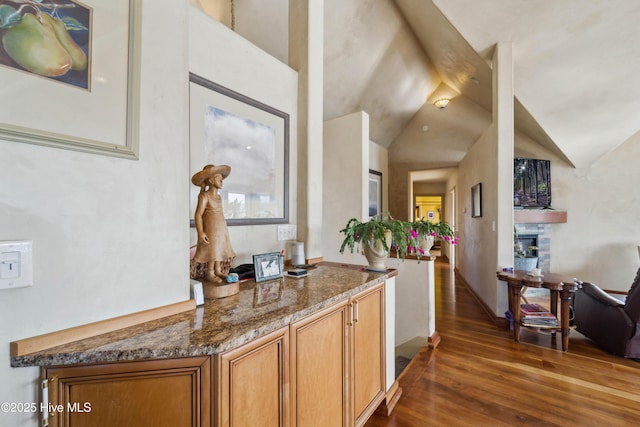 hallway featuring lofted ceiling and dark hardwood / wood-style floors