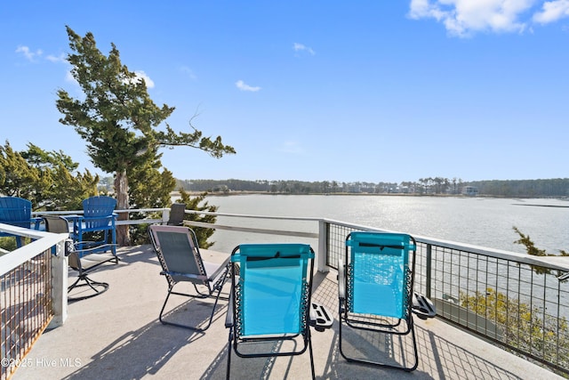 view of patio featuring a balcony and a water view