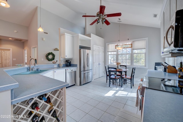 kitchen with stainless steel appliances, decorative light fixtures, sink, and white cabinets