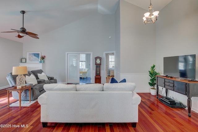 living room featuring ceiling fan with notable chandelier, hardwood / wood-style floors, and high vaulted ceiling