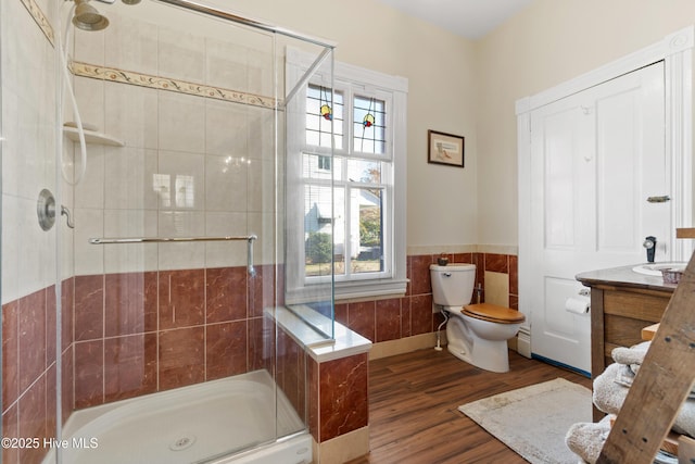 bathroom featuring vanity, hardwood / wood-style floors, a shower with shower door, and tile walls