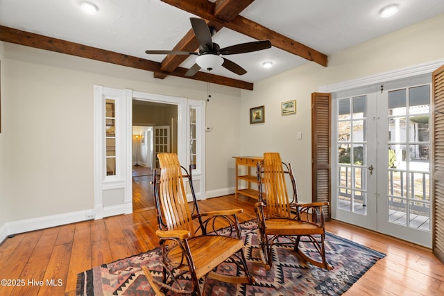 living area featuring hardwood / wood-style floors, beam ceiling, french doors, and ceiling fan