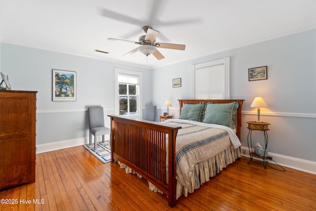 bedroom featuring hardwood / wood-style flooring, ornamental molding, and ceiling fan