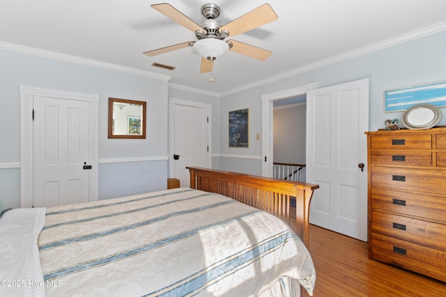 bedroom with crown molding, ceiling fan, and light hardwood / wood-style flooring