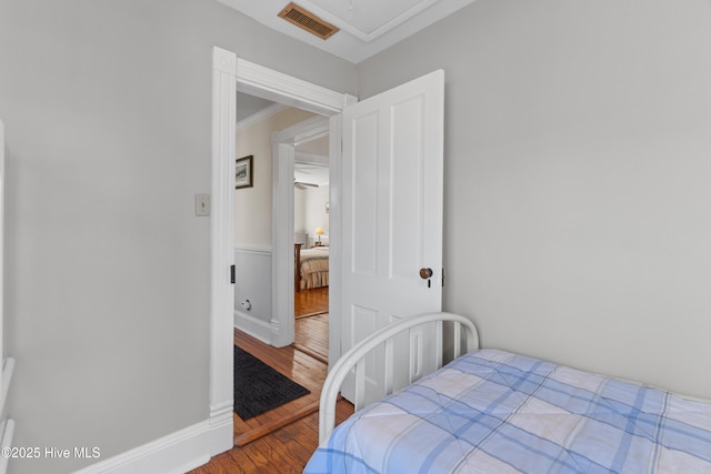 bedroom with hardwood / wood-style flooring and ornamental molding