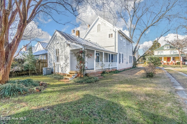 view of front of home featuring cooling unit, a porch, and a front yard