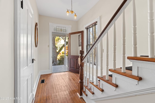 entryway featuring hardwood / wood-style flooring and a chandelier