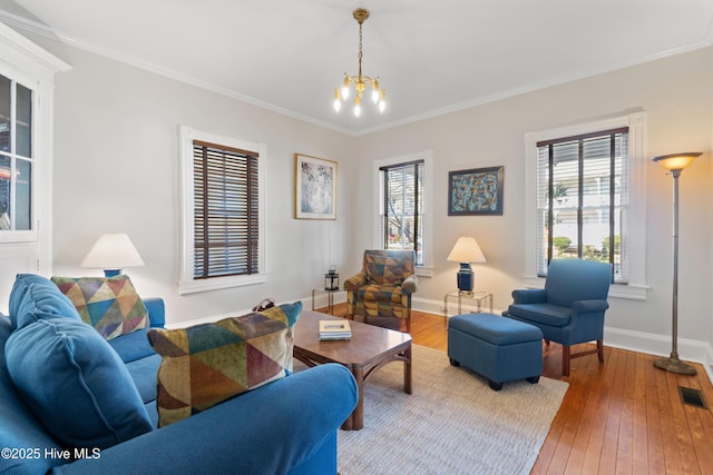 living room featuring hardwood / wood-style flooring, crown molding, and a notable chandelier