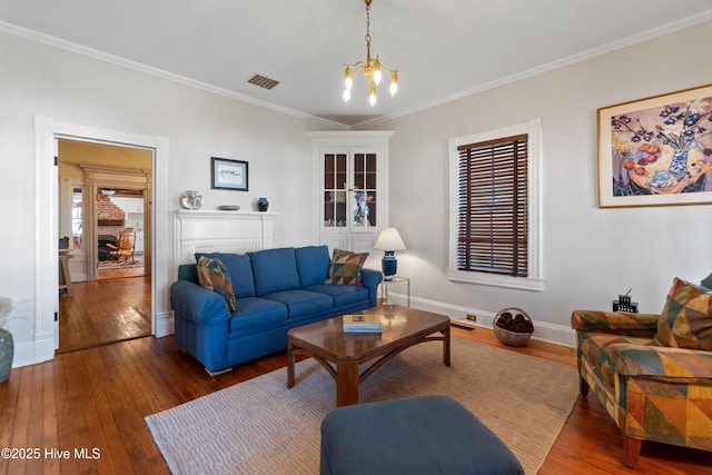 living room featuring crown molding, dark hardwood / wood-style floors, and a chandelier