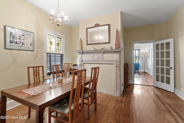 dining room featuring a notable chandelier, wood-type flooring, and plenty of natural light