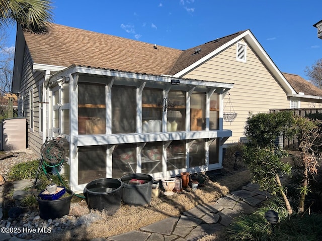 back of property with a sunroom