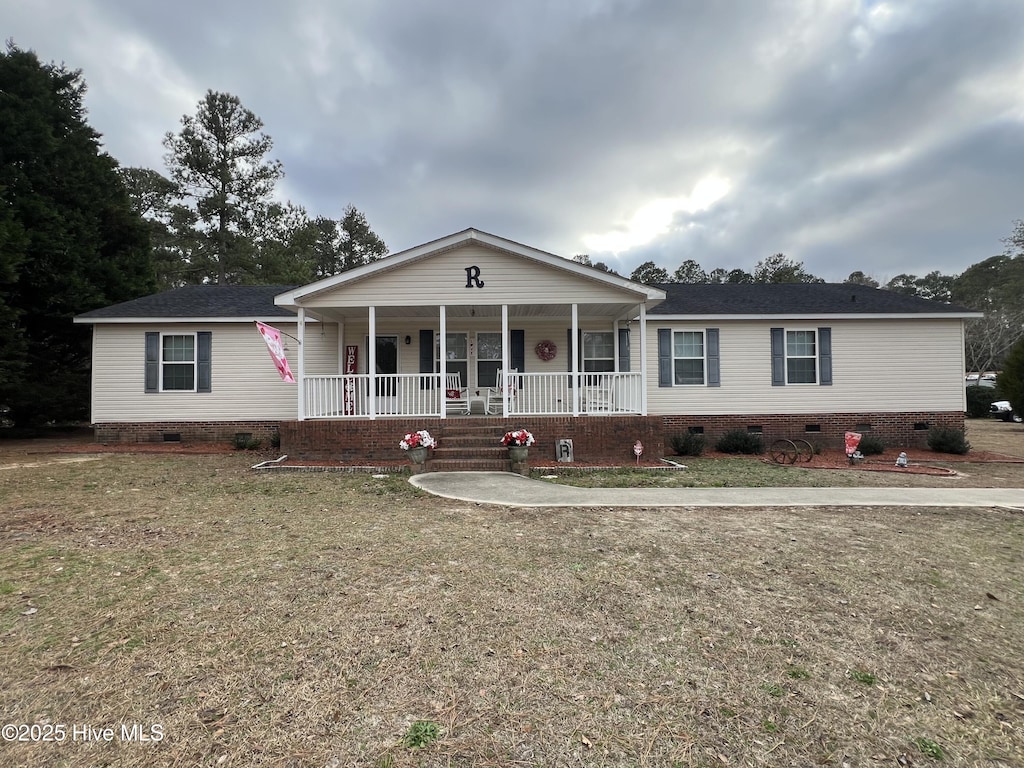 ranch-style house with covered porch and a front lawn