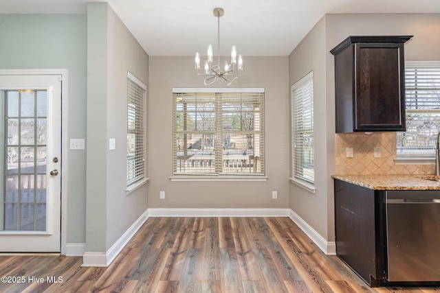 unfurnished dining area with dark wood-type flooring and an inviting chandelier