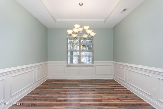 unfurnished dining area featuring a chandelier, dark hardwood / wood-style floors, and a raised ceiling