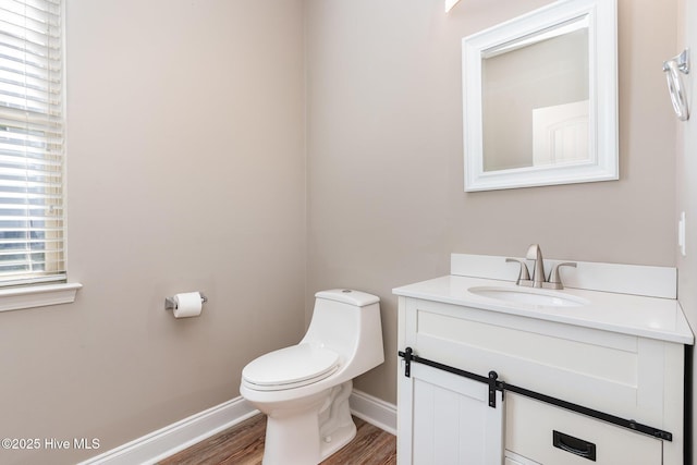 bathroom with vanity, toilet, and hardwood / wood-style floors