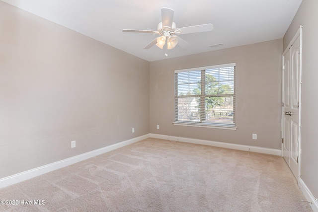 spare room featuring light colored carpet and ceiling fan