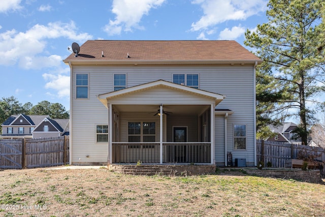 rear view of property with ceiling fan, a sunroom, and a lawn