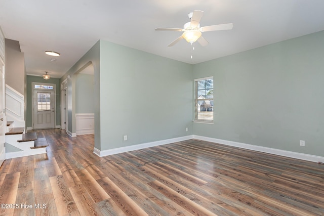 spare room with ceiling fan, a healthy amount of sunlight, and dark hardwood / wood-style floors