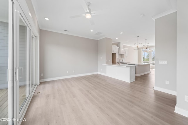 2660 Alvernia Dr, Castle Hayne, NC 28429 - unfurnished living room with a sink, light wood-style flooring, baseboards, a ceiling fan, and crown molding
