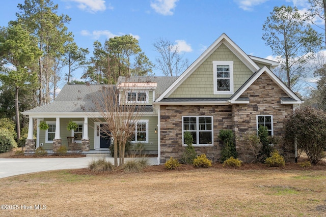 craftsman-style home featuring covered porch and a front yard