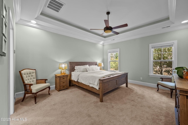 bedroom featuring a tray ceiling, visible vents, and light carpet