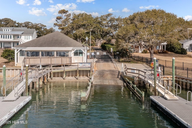 view of dock featuring a water view and fence