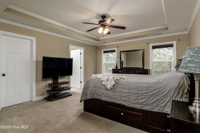 bedroom with crown molding, light colored carpet, a raised ceiling, and ceiling fan