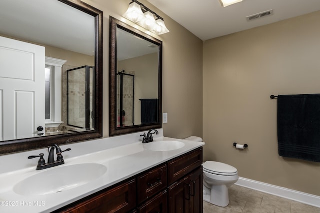 bathroom with tile patterned flooring, vanity, toilet, and walk in shower