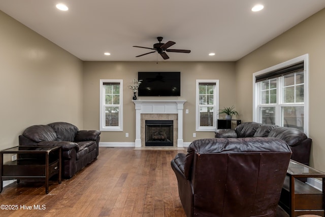 living room with a fireplace, wood-type flooring, and ceiling fan