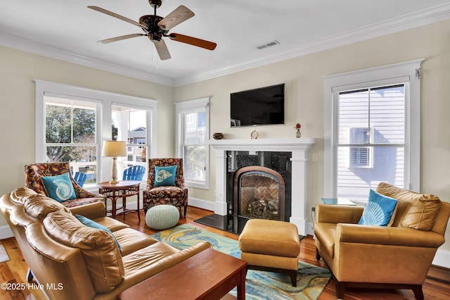 living room with hardwood / wood-style floors, a wealth of natural light, and ornamental molding