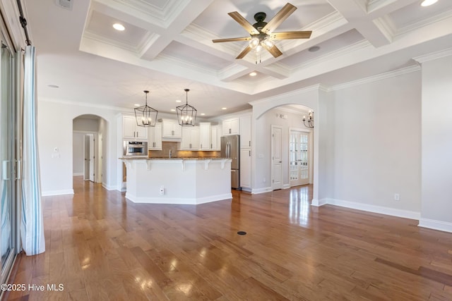 interior space featuring coffered ceiling, ceiling fan with notable chandelier, beam ceiling, and dark hardwood / wood-style floors