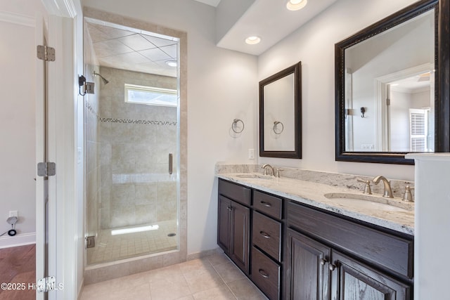 bathroom with a shower with door, vanity, and tile patterned floors